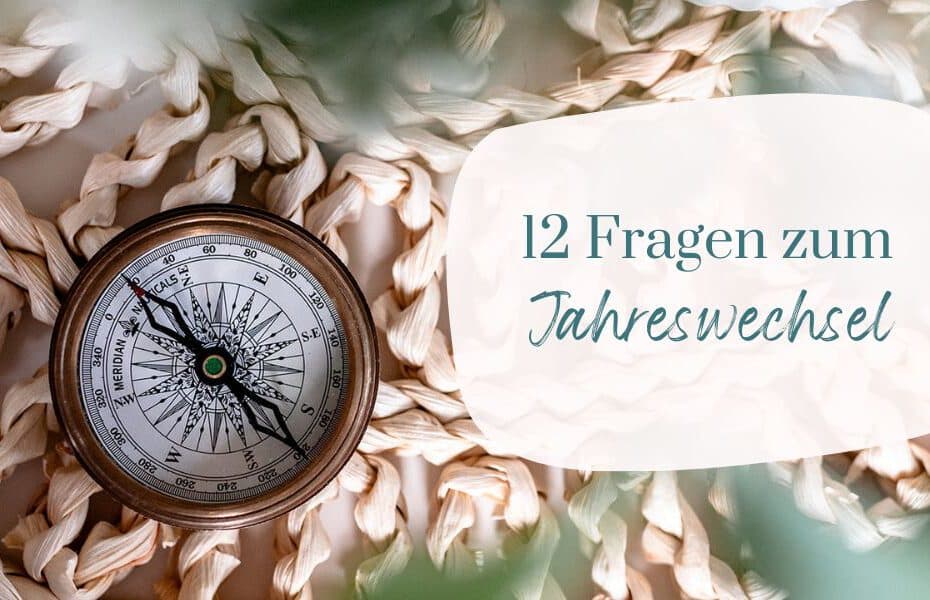 Kompass auf einer geflochtenen Unterlage, im Vordergrund verschwommene Blätter. Text: 12 Fragen zum Jahreswechsel